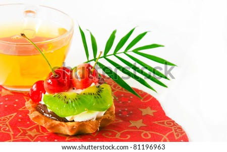 Fruit cake and cup of green tea on a white background