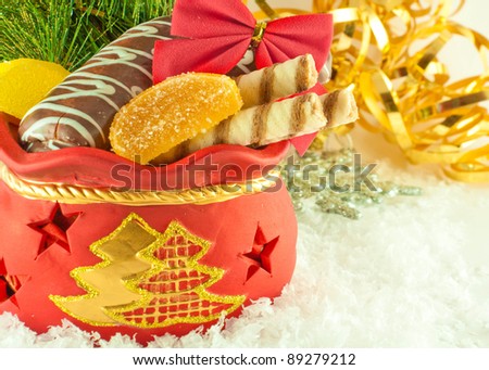 Christmas bag with gifts, cookies and fruit candy, a fur-tree branch