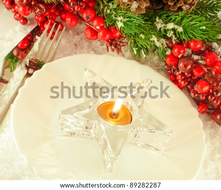 Christmas table layout, candlestick in the form of a star with a branch of berries