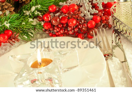 Christmas table layout, candlestick in the form of a star with a branch of berries