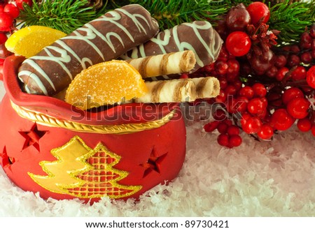 Christmas bag with gifts, cookies and fruit candy, a fur-tree branch
