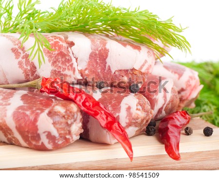 Meat rolls with fennel and red pepper on a bamboo board