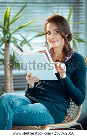 Young woman reading a book with a blank cover