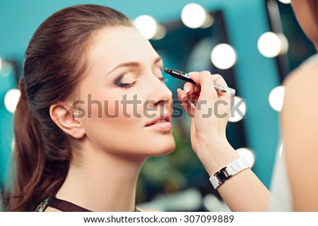 Make-up artist and model at work, close up of model