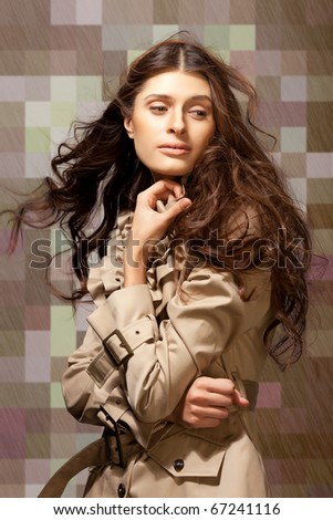 Young elegant woman with long frizzy hair on abstract checkered background.