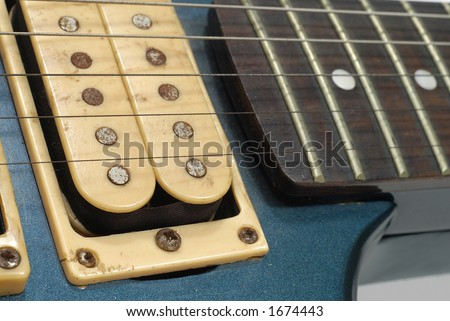 close up of an old electric guitar pickups and frets