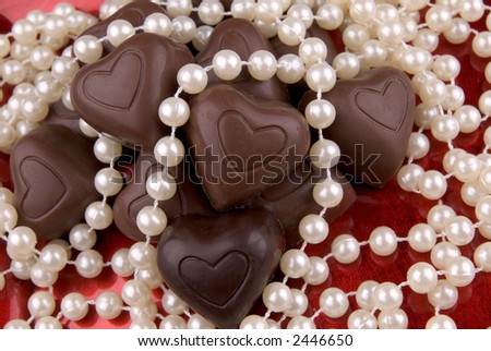 Chocolate heart candy on a red plate with pearls