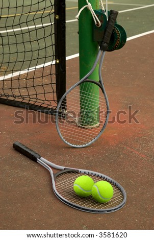 Tennis court with balls and rackets in front of net