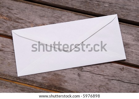 Plain white envelope on a wood picnic table