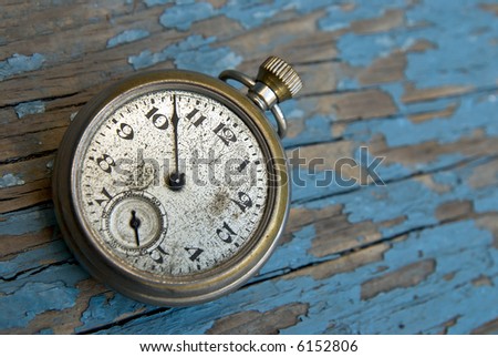 Antique pocket watch clock on a peeling blue wood floor