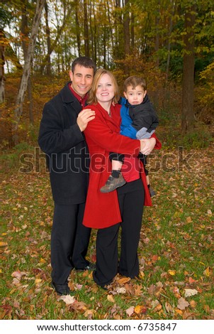Family of three at a park or backyard in the fall.