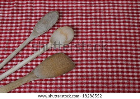 Wooden kitchen-ware isolated on a red and white tablecloth