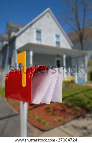 A standard red mailbox american money and flag in front of a house