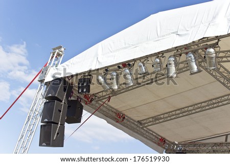 Outdoor concert stage roof construction with speakers  over sky