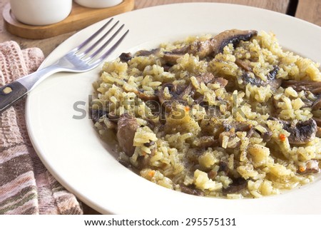 Risotto with mushrooms on plate with fork