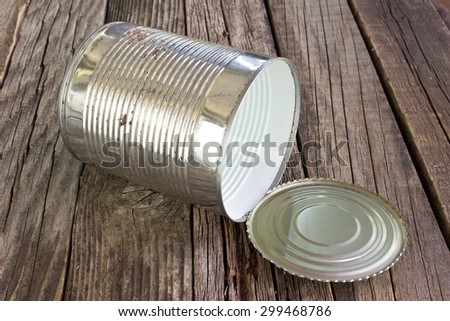 Open empty tin can on wooden background