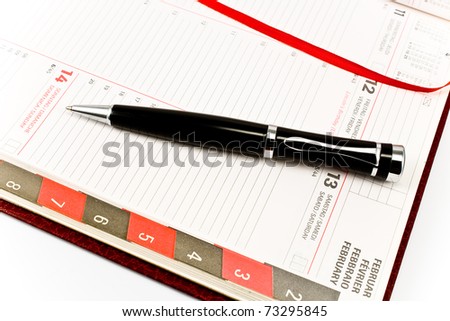 Pen on personal organizer isolated on white
