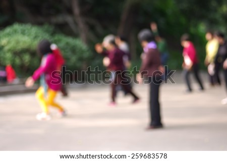 Blurred image of   chinese people practicing  tai chi in Park