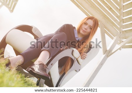 beautiful happy woman has a rest in chair on bank of the lake morning