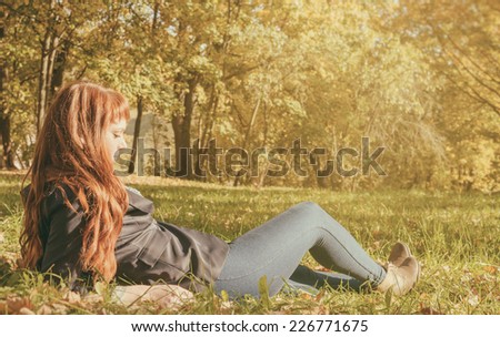 beautiful woman with red long hair in autumn park