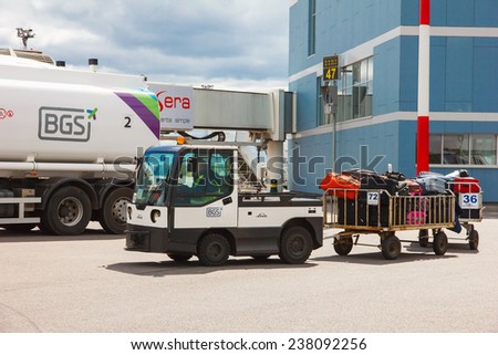 Vilnius, Lithuania - May 2, 2014: Passenger baggage is carried on the airfield of the airport on the plane.