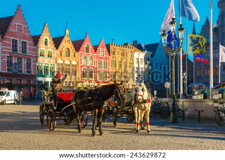 Bruges, Belgium - December 28, 2014: Horse carriage waiting tourists on Grote Markt square of Brugge Christmas. Belgian city of Bruges is UNESCO world heritage listed for its medieval center.
