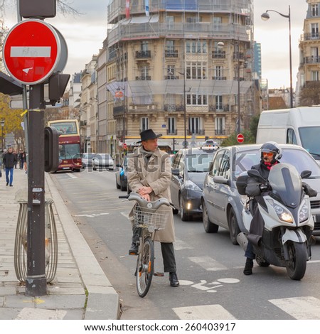 Paris, France - December 20, 2014: Cyclists and motorcyclists on a busy intersection in Paris waiting for the green light.