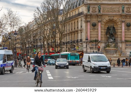 Paris, France - December 20, 2014: Typical Parisian street with cyclists, tourists and cars. Paris - the worlds largest tourist center, in the year it is visited by about thirty million tourists.
