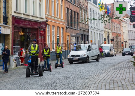 Bruges, Belgium - December 26, 2014: Tourists ride Segway on Christmas streets of city center. Bruges - one of the most beautiful and wonderfully preserved medieval cities in Europe.