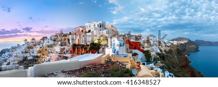 Picturesque panorama, Old Town of Oia or Ia on the island Santorini, white houses, windmills and church with blue domes at sunset, Greece