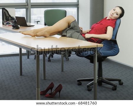 Woman in the office while resting with feet on the table