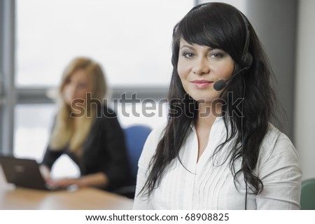 Woman telephonist in white blouse in the office with a friend