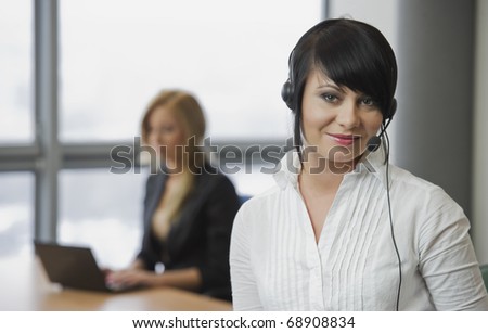 Woman telephonist in white blouse in the office with a friend