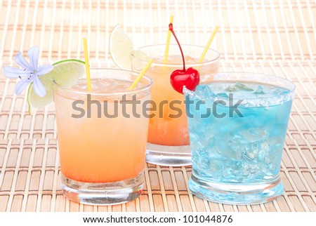 Alcohol margarita cocktails, long island Iced tea, blue lagoon with lime and summer flower in short cocktail glasses isolated on a white background