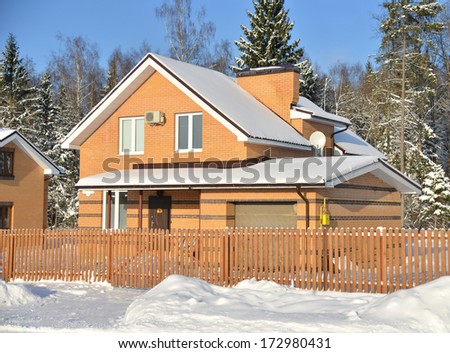 Brick cottage house in winter time close to forest