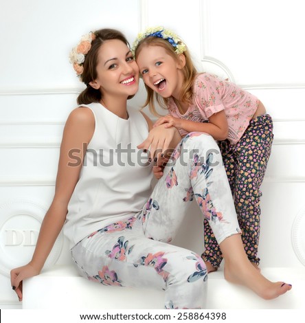 Happy mother and four years old daughter laughing together hugging smiling isolated on a white background