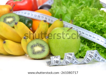 Diet weight loss breakfast concept with tape measure organic green apple salad bananas kiwi avocado grapefruit red pepper pear on a white background
