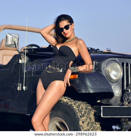 Happy beautiful young girl standing near beach truck car in sunglasses on sunny summer day