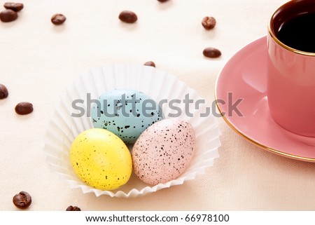 Easter Sunday morning  with three pink, blue and yellow eggs, cup of coffee and beans for happy Christian family on a pastel color background