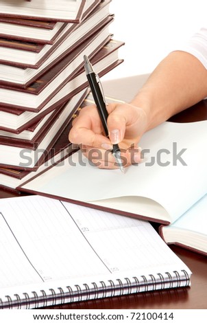 Writer business person hand with pen signing document. On the table stack of books organizer notebook on white background