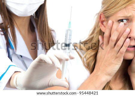 Nurse hand with syringe needle and woman fear of injections phobia concept against white background. Focus on hand
