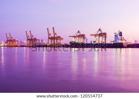early morning twilight at industrial cargo harbor along river