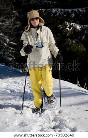 Woman snow shoeing in the in the woods
