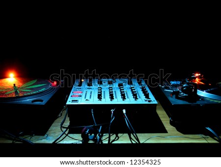 2 DJ turntables and electronic mixer in darkness