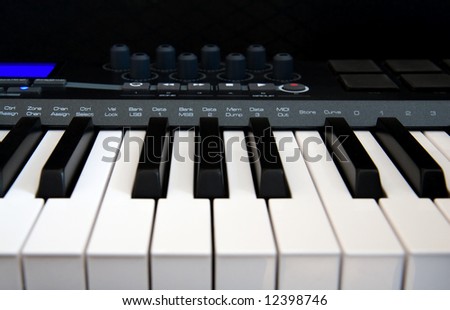 The Part of Professional MIDI-keyboard with blue screen on black background