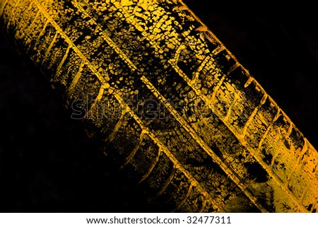 Yellow car tire print on black background