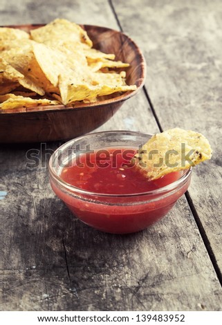 Bowl of Salsa and tortilla chips on the  wooden table
