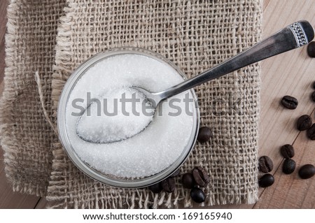 Spoon in a glass bowl of sugar, close up