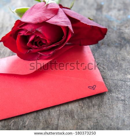 Red rose and  Red envelope on wooden background