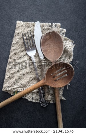 A mess of silver cutlery on a rustic background